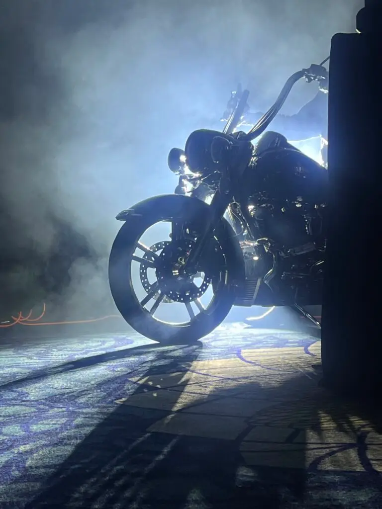 Managing director arriving at a corporate event on a Harley-Davidson motorcycle with dramatic stage lighting and smoke effects on the Gold Coast.